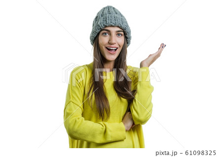 Winter portrait of an emotional girl in yellow sweater and a knitted cap, white background isolated Winter portrait of an emotional girl in yellow sweater and a knitted cap, white background isolated 61098325