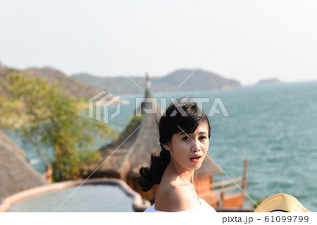 夏のアジアの海岸線に海を背景に肩出し若い女性が1人 夏のアジアの海岸線に海を背景に肩出し若い女性が1人 61099799