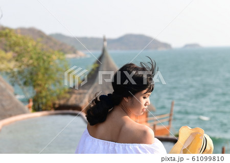 夏のアジアの海岸線に海を背景に肩出し若い女性が1人 夏のアジアの海岸線に海を背景に肩出し若い女性が1人 61099810