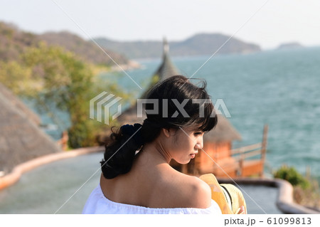 夏のアジアの海岸線に海を背景に肩出し若い女性が1人 夏のアジアの海岸線に海を背景に肩出し若い女性が1人 61099813
