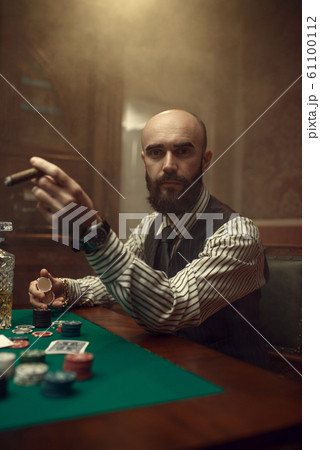 Bearded poker player with cigar playing in casino Bearded poker player with cigar playing in casino 61100112