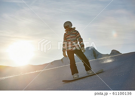 Snowboarder in sun flare, water drops on lens Snowboarder in sun flare, water drops on lens 61100136