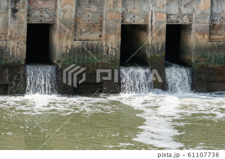Dirty water flows from a pipe,Sewage pipe polluting water	 61107736