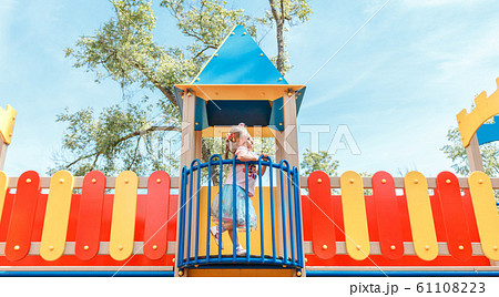 Smiling little girl at playground in the park 61108223