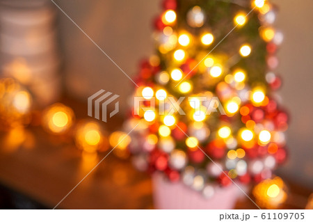 Abstract blur. Beautiful small Christmas tree of moss on wooden table. Happy mood. Garland lamp bokeh on background. Abstract blur. Beautiful small Christmas tree of moss on wooden table. Happy mood. Garland lamp bokeh on background. 61109705
