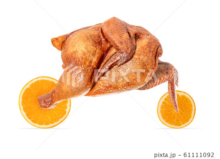 Appetizing grilled chicken with browned skin rides on orange slices like a racing motorcycle. Concept: food delivery, fast delivery. Appetizing grilled chicken with browned skin rides on orange slices like a racing motorcycle. Concept: food delivery, fast delivery. 61111092