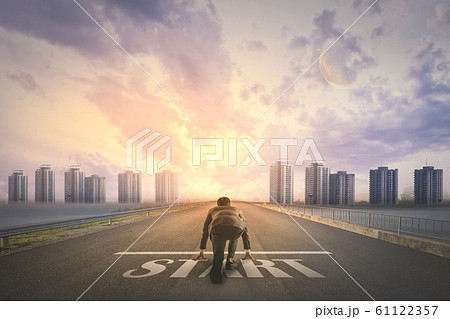 Asian business person ready to run START toward Asian business person ready to run START toward 61122357