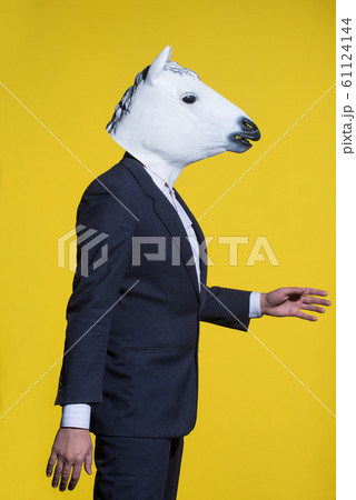man with horse mask on yellow background 61124144