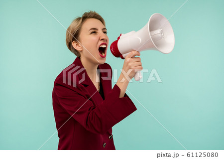 Angry businesswoman with a megaphone on blue 61125080
