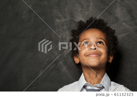 Little child boy looking up on blackboard 61132325