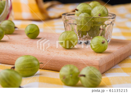 Green cherry-plums on a wooden board. Green cherry-plums on a wooden board. 61135215