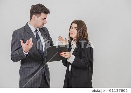 Cute young secretary brought document, which boss has to sign, but he doesn't understand and don't want to sign, frowning. 61137602
