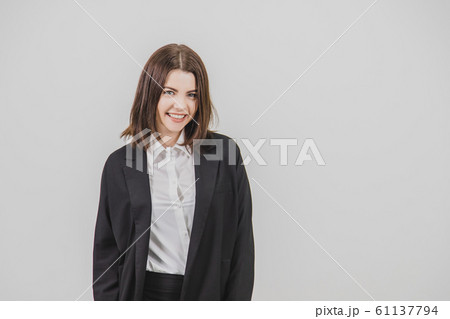 Pretty businesswoman wearing black suit, standing, smiling, looking extremely happy. Pretty businesswoman wearing black suit, standing, smiling, looking extremely happy. 61137794