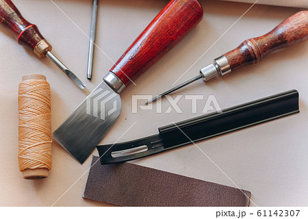 set of leathercraft tools - Slickers, Nylon hammers, Edge Creaser, Burnishers, Swivel knifes, Edge Beveler Skiving, Hole Punches, Prongs Lacing Stitching Chisels isolated on white background. 61142307