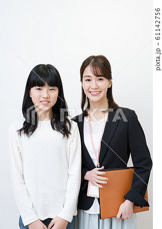 塾講師と生徒イメージ 白バック 女性 小 中学生の写真素材