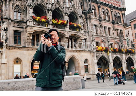 Young Asian traveling backpacker in city centre in Europe. Man taking photos in Marienplatz square, Munich, Germany Young Asian traveling backpacker in city centre in Europe. Man taking photos in Marienplatz square, Munich, Germany 61144078