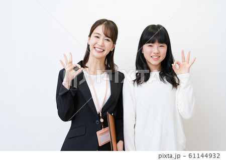 塾講師と生徒イメージ(OKポーズ、白バック、女性、小・中学生 塾講師と生徒イメージ(OKポーズ、白バック、女性、小・中学生 61144932