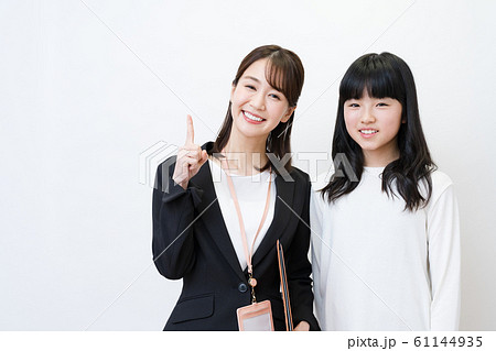 塾講師と生徒イメージ 白バック 女性 小 中学生の写真素材