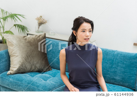 ソファに座る若い女性 61144936