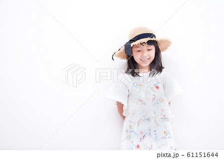 麦わら帽子を被ったお洒落な小学生の女の子の写真素材