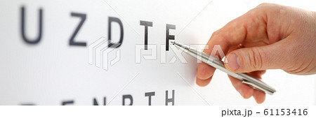 Silver ballpoint pen pointing to letter in eyesight check table 61153416