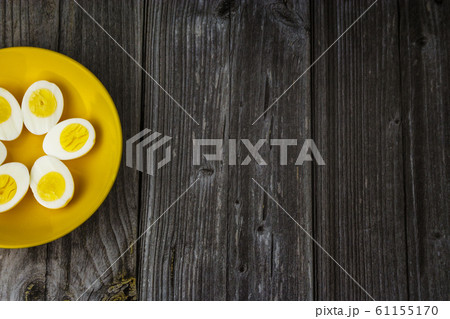 Boiled egg halves in a yellow bowl on wooden table Boiled egg halves in a yellow bowl on wooden table 61155170