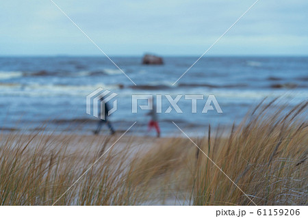 A couple walks along the beach in the evening in winter 61159206