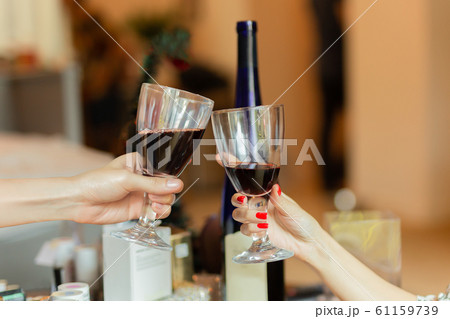 Hand clinking glasses with white wine to celebration holiday. Hand clinking glasses with white wine to celebration holiday. 61159739