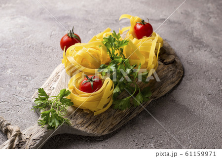 Raw pasta tagliatelle or fettuccine Raw pasta tagliatelle or fettuccine 61159971
