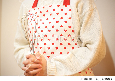 泡立て器を持ったエプロンの女性 泡立て器を持ったエプロンの女性 61164063