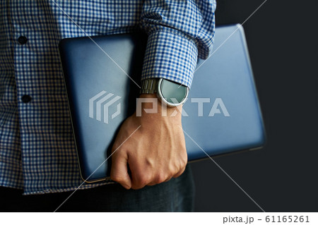 Laptop in hand. 61165261