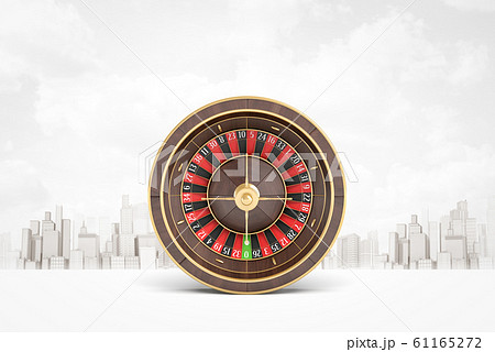3d rendering of casino wheel against white background with skyline of modern city in the distance. 61165272