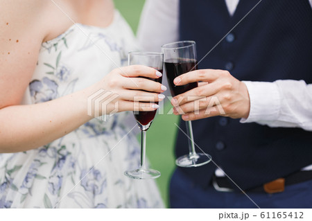 Bride and groom holding glasses with champagne and clink Bride and groom holding glasses with champagne and clink 61165412