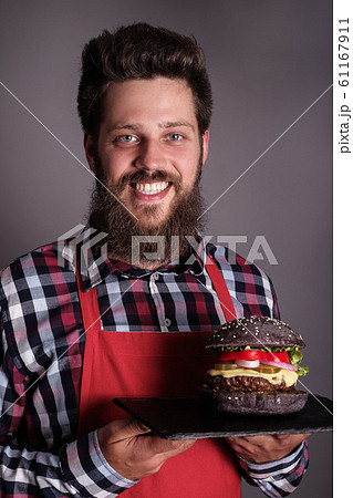 Male cook hold black burger Male cook hold black burger 61167911