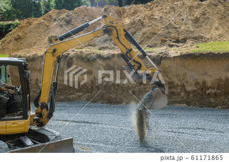 Excavator with a bucket standing on gravel stones Excavator with a bucket standing on gravel stones 61171865
