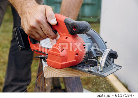 Carpenter cutting wooden plank hand held electric Carpenter cutting wooden plank hand held electric 61171947