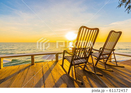 Empty wood chair and table at outdoor patio with beautiful tropical beach and sea Empty wood chair and table at outdoor patio with beautiful tropical beach and sea 61172457