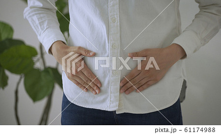 下腹部をさする若い女性 下腹部をさする若い女性 61174988