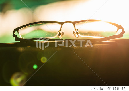 Close-up glasses with camera flare at sunrise Close-up glasses with camera flare at sunrise 61176132