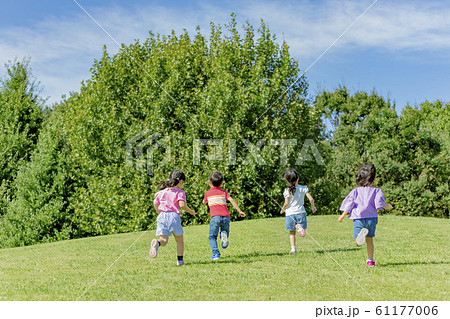 公園を走る子供たちの後ろ姿の写真素材