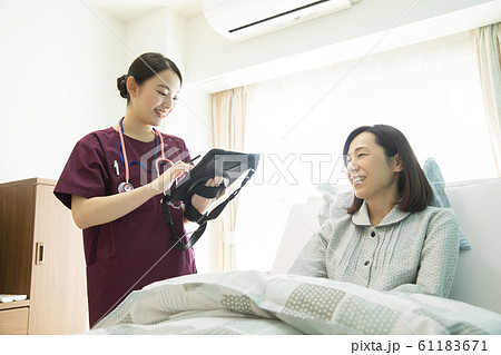 女性　ビジネス　仕事　医者　看護師　病院　電子カルテ　タブレット　患者　カウンセリング　診察 61183671