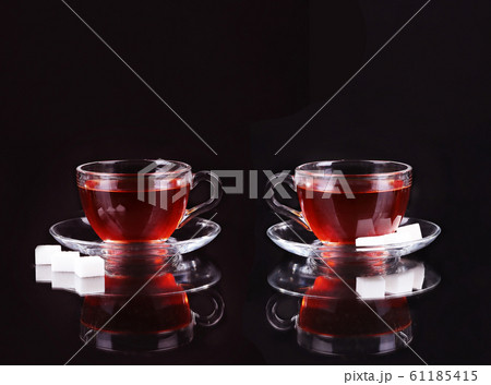 Glass cup of tea on black background. 61185415