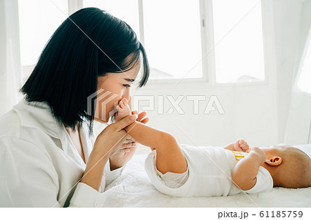 Mother kissing feet of newborn baby Mother kissing feet of newborn baby 61185759