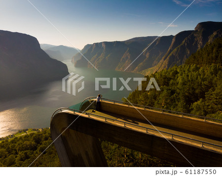 Tourist enjoying fjord view on Stegastein 61187550