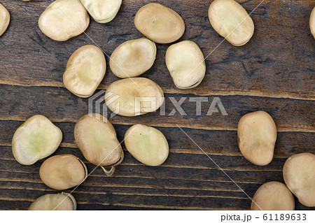 dry broad beans on a wooden background dry broad beans on a wooden background 61189633
