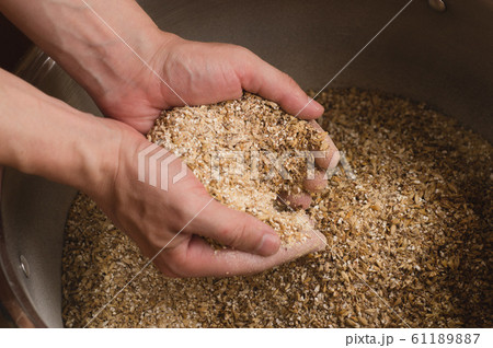 Male hands from which ground malt pours out. good Male hands from which ground malt pours out. good 61189887