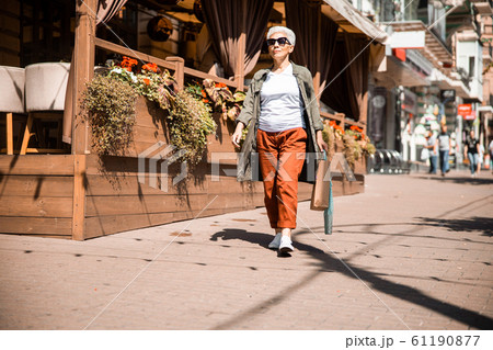 Elegant mature woman walking on the street Elegant mature woman walking on the street 61190877