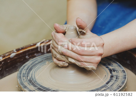 Woman hands on pottery wheel. Craftsman artist Woman hands on pottery wheel. Craftsman artist 61192582