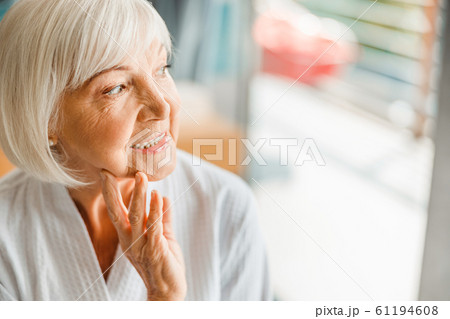 Joyful elderly lady looking away and smiling 61194608