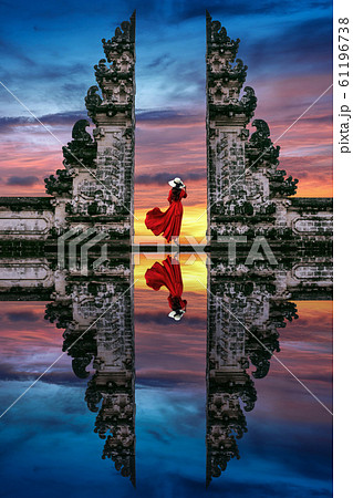 Young woman standing in temple gates at Lempuyang Luhur temple in Bali, Indonesia. Young woman standing in temple gates at Lempuyang Luhur temple in Bali, Indonesia. 61196738